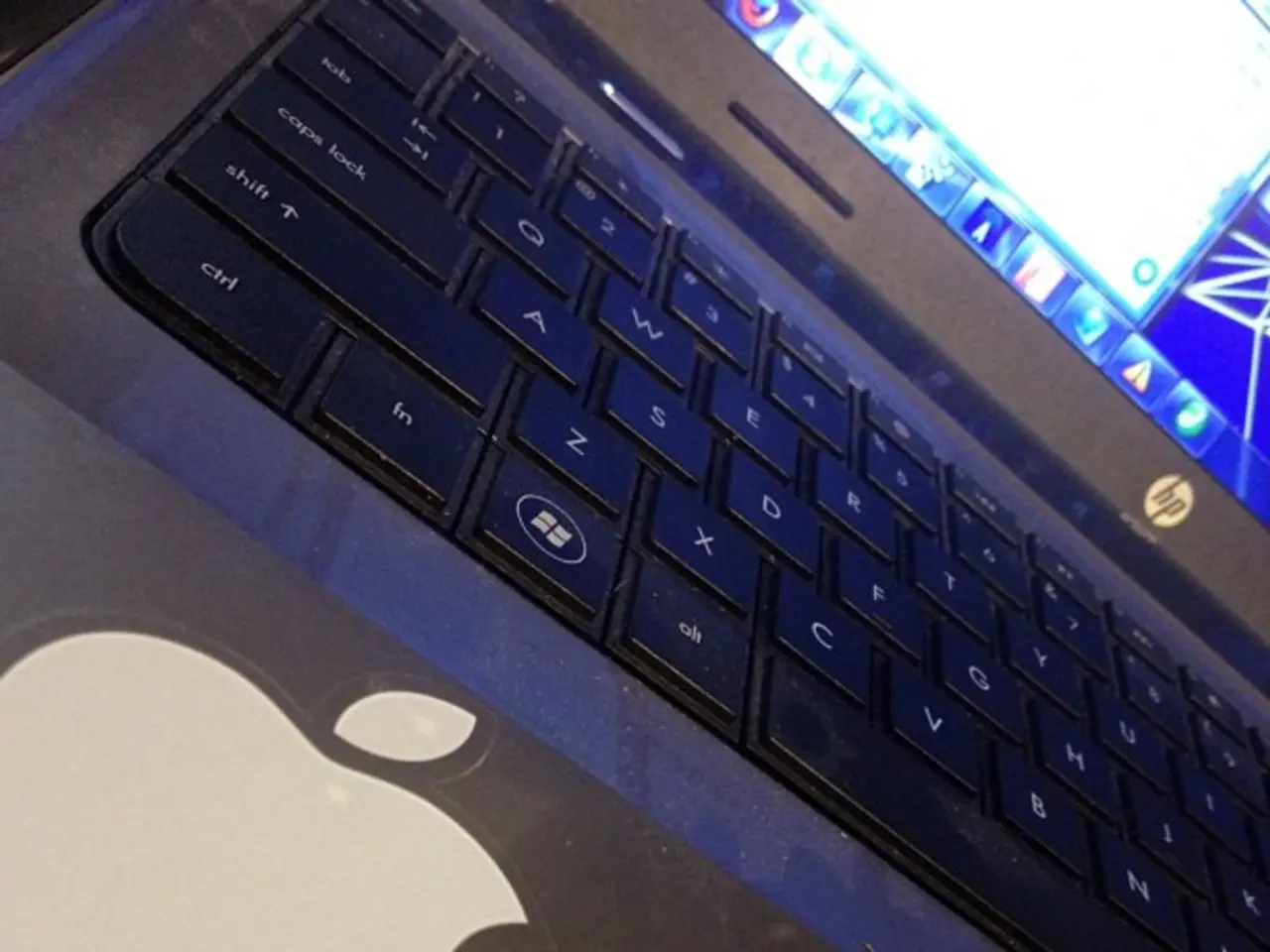 In this image we can see a laptop, on the screen, we can see some applications.