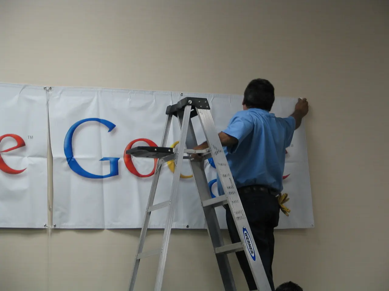 In the image we can see there is a man standing on the ladder and he is pasting the banner on the...