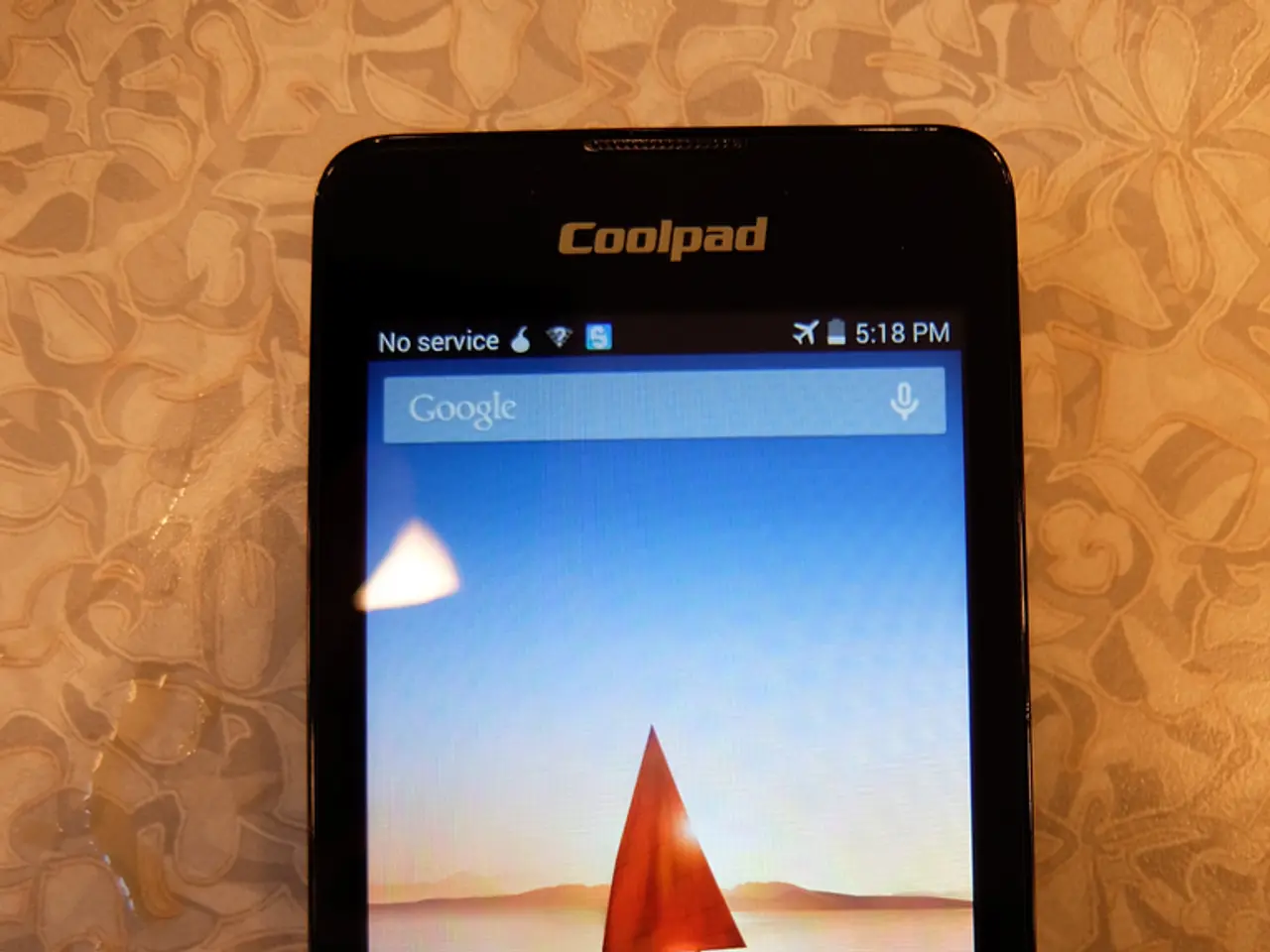 Here in this picture we can see a mobile phone present over a place and on its screen, we can see a...