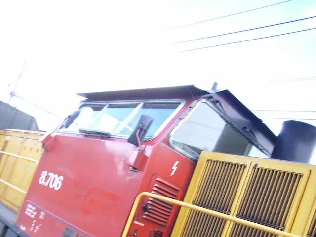 In this image there is a train on the track. In the background there are a few cables and the sky.