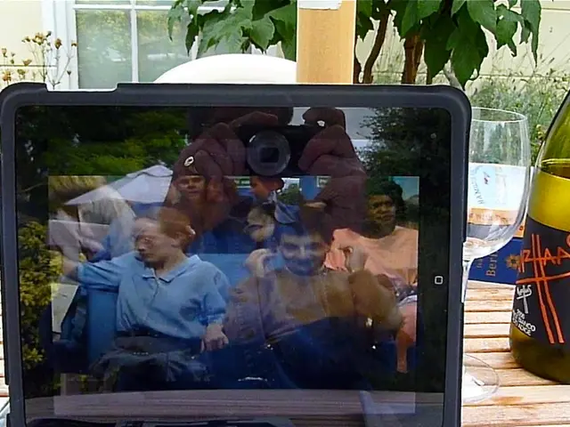 In this image I see an electronic device, in which there is a picture playing in it and I see 2...