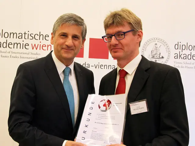 In this image we can see two men are standing and holding a laminated paper in their hands. In the...