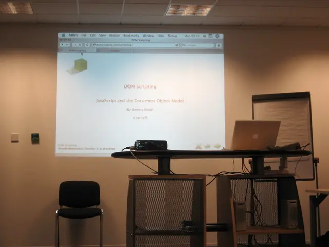 In this image we can see a laptop placed on a table. To the right side of the image we can see a...