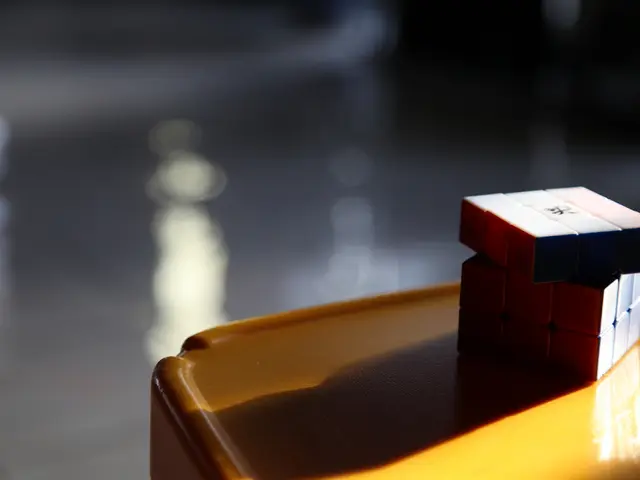 On the right side of the image there is a rubix cube which is placed on the table.