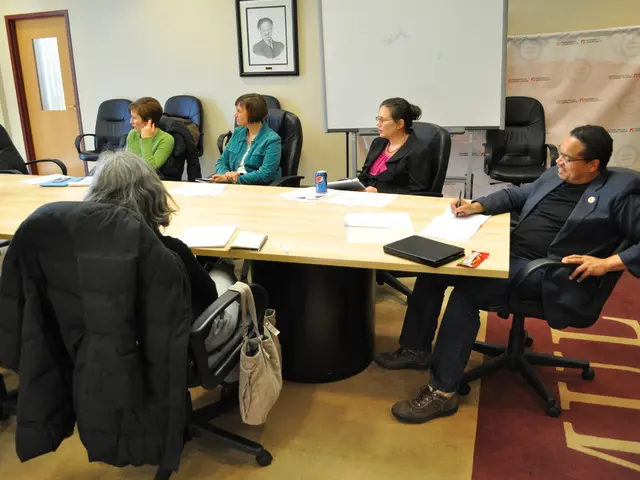 In the image we can see there are people who are sitting on chair, the chairs are in black colour...