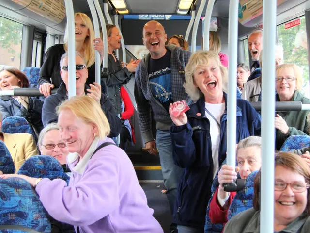 In this image there are a few people sitting and standing on a bus with a smile on their face.