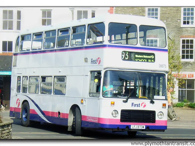 In this image there is a bus on the road. Beside the bus there are two persons walking on the road....